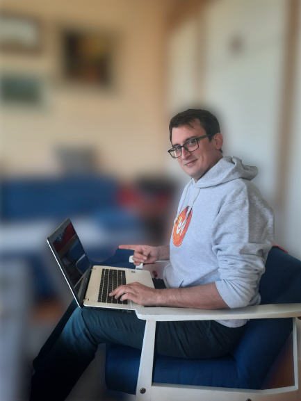 Filip Dorić pokazuje prstom na laptop s video materijalima SFT21, noseći bijelu hoodie majicu s logom kompanije SFT21